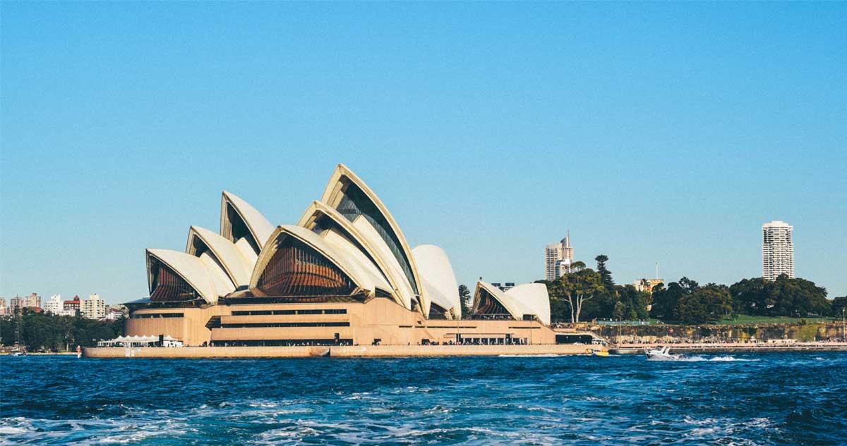 fotografía de la opera de Sydney desde el mar y de fondo el cielo despejado