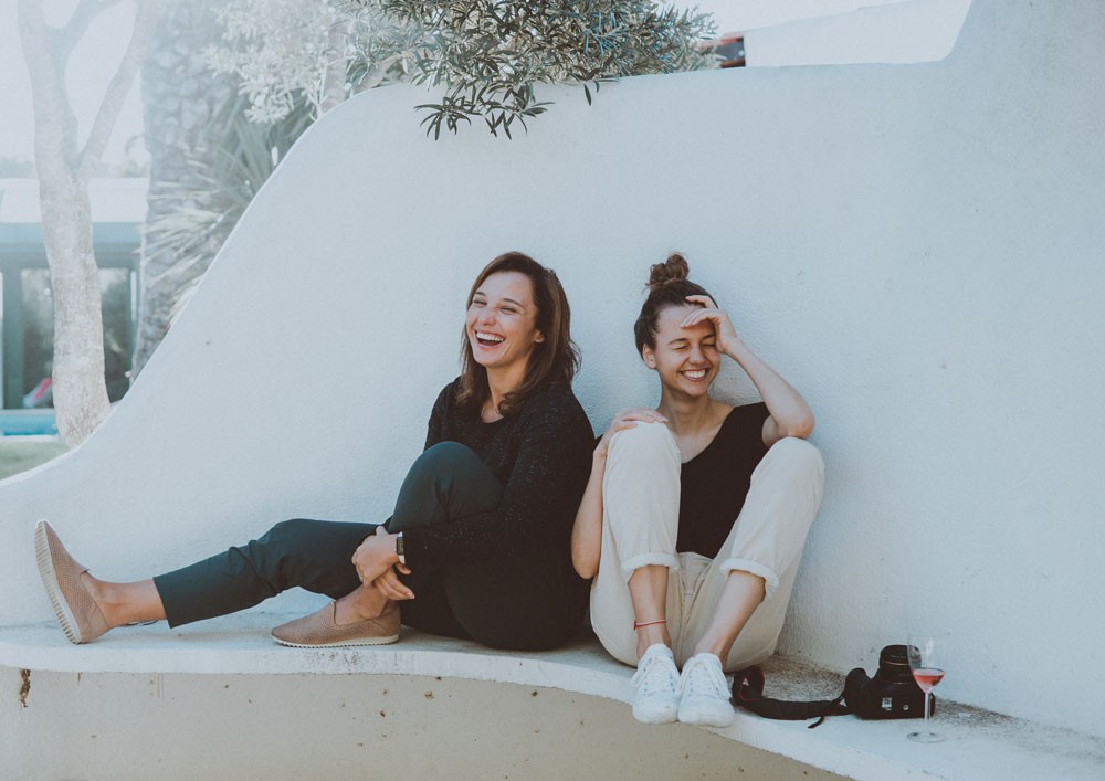 dos amigas sentadas y riendo