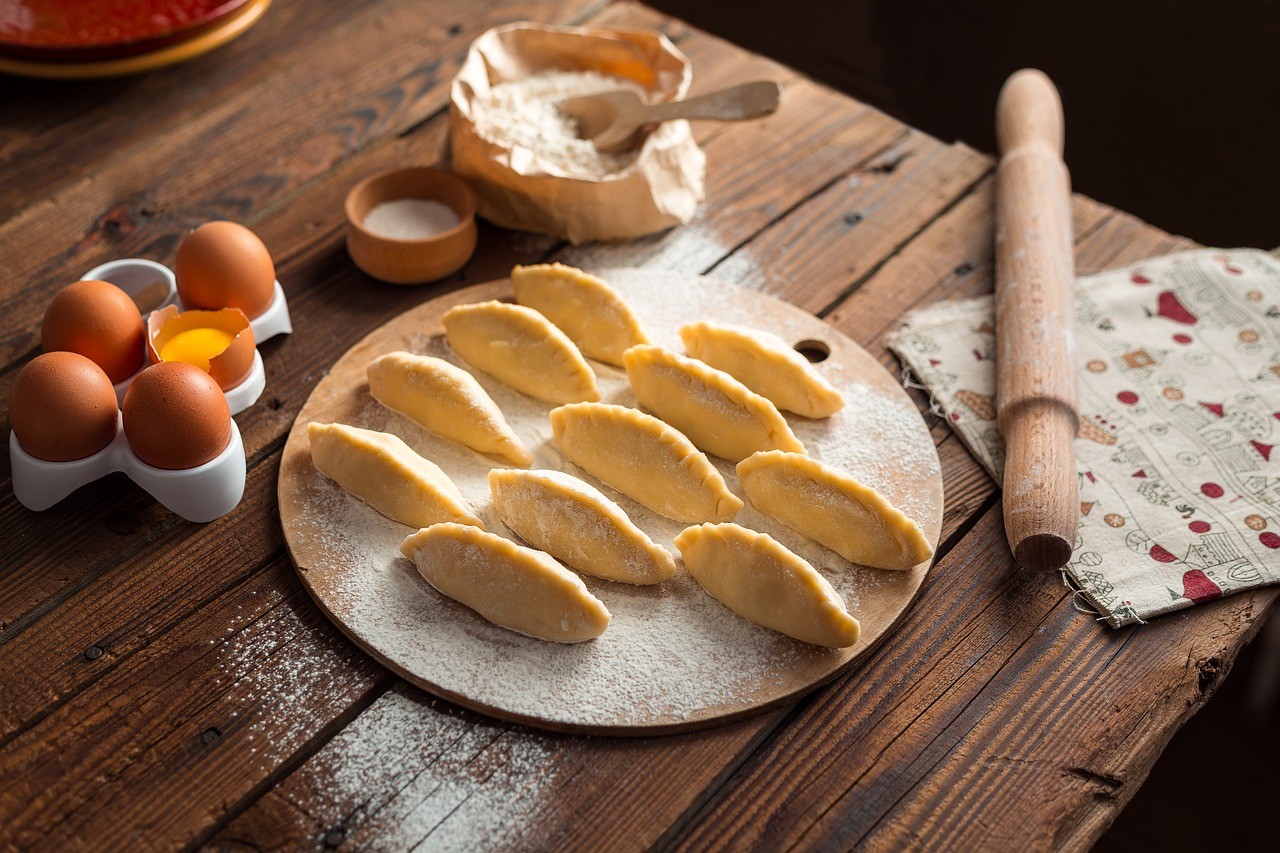 imagen de pasta sobre una mesa con un poco de harina y huevos