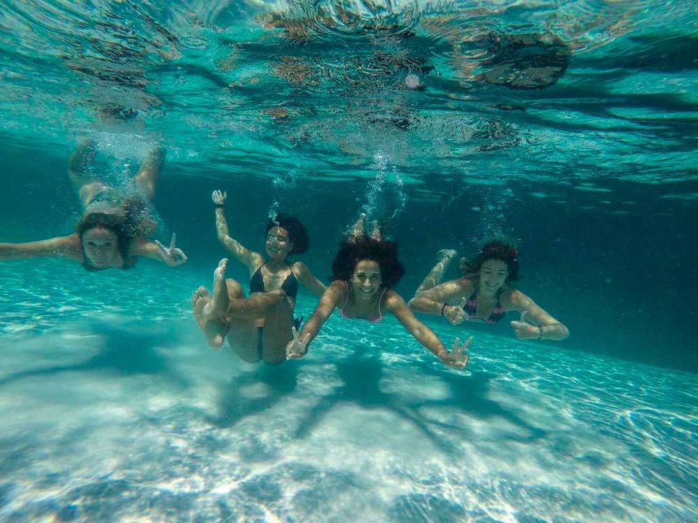 cuatro chicas nadando debajo del agua