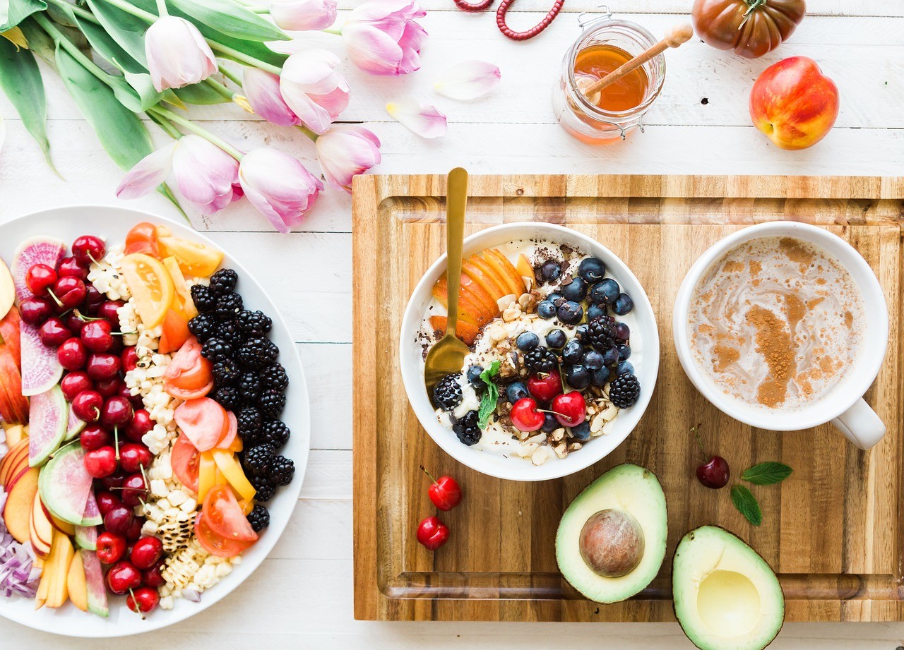 imagen de una mesa con frutas miel 2 guindas y un aguacate partido