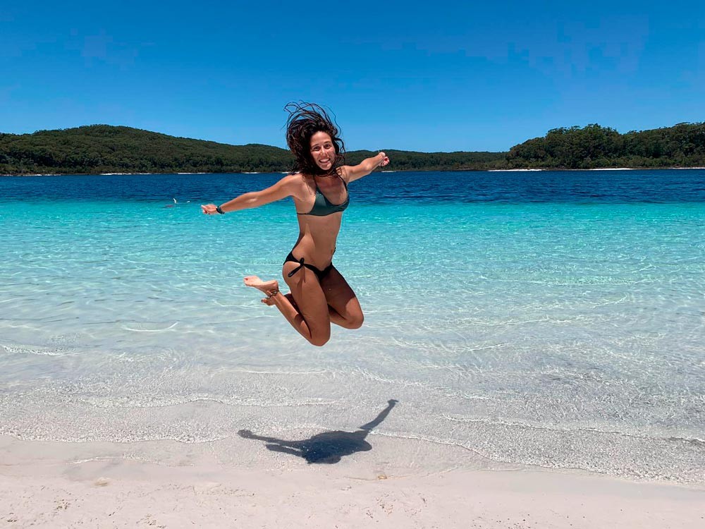 chica saltando en un lago