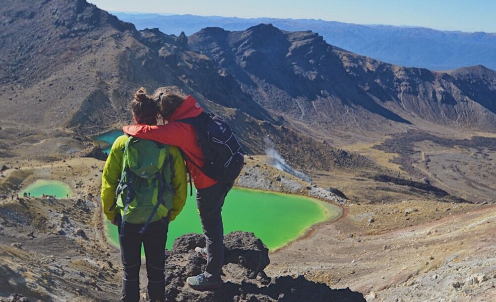 pareja abrazados y de espaldas y delante un volcán 