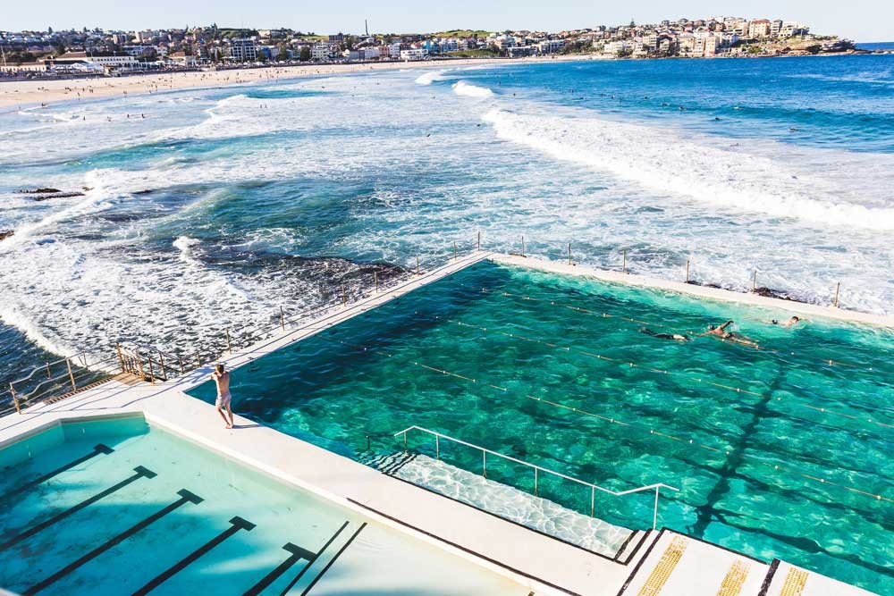 fotografía de dos piscinas y debajo una playa