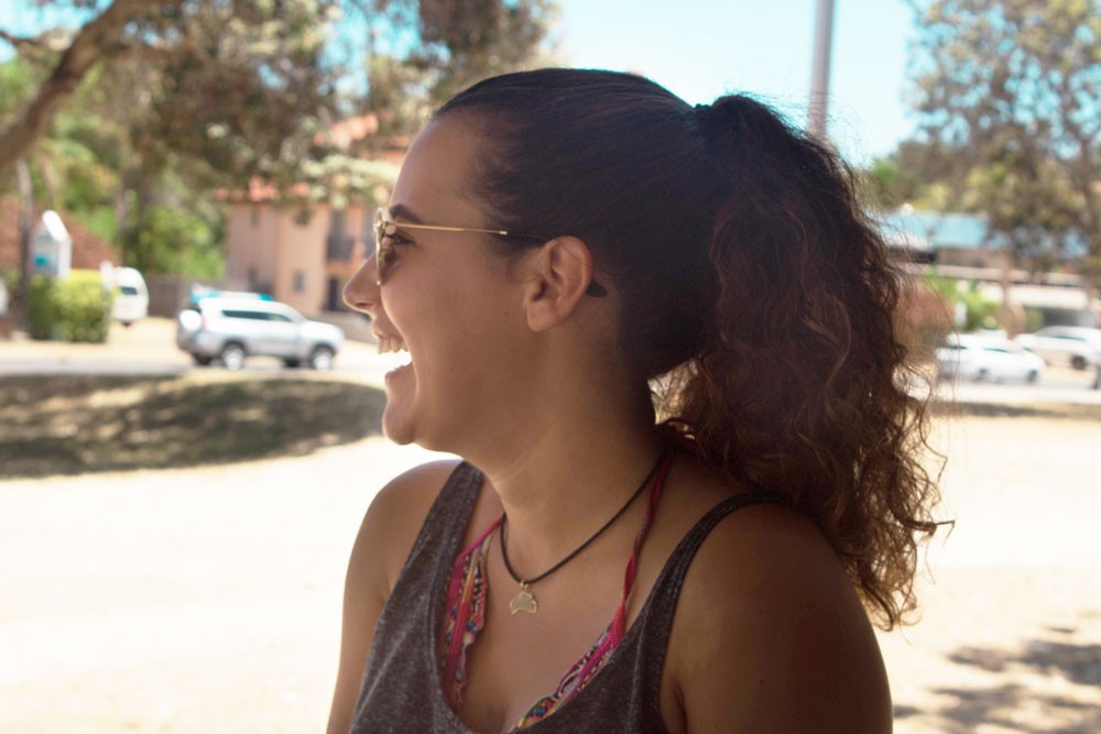 chica morena con una coleta sonriendo 