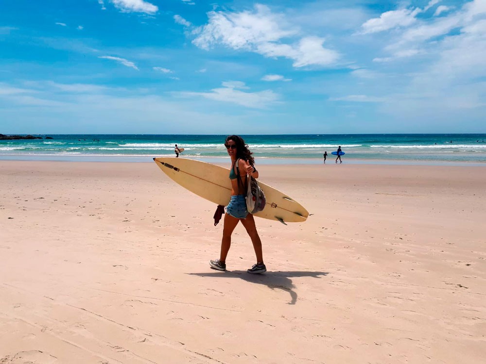 chica con tabla de surf en la playa